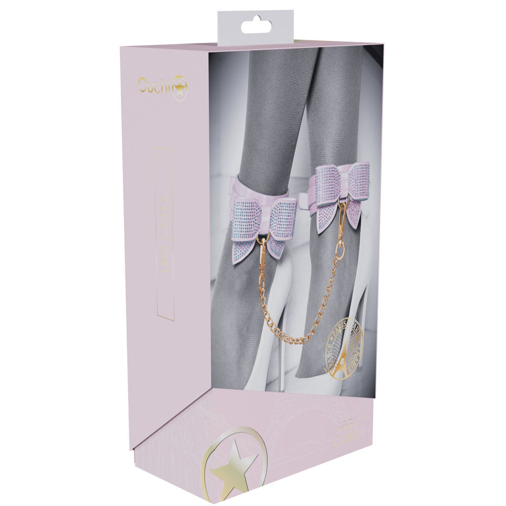 Product packaging with gray tights featuring purple bow and gold chain, on a white background.