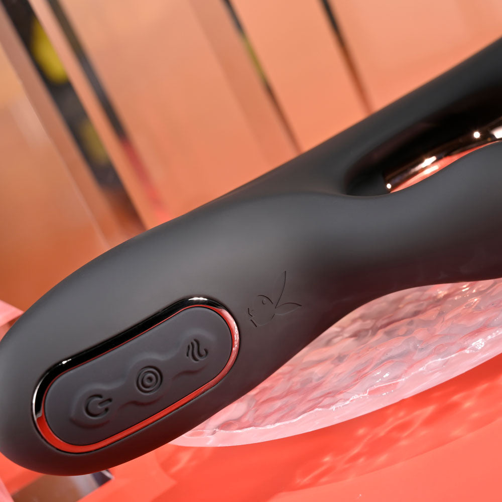 Close-up of a black hair straightener handle with control buttons on a red background