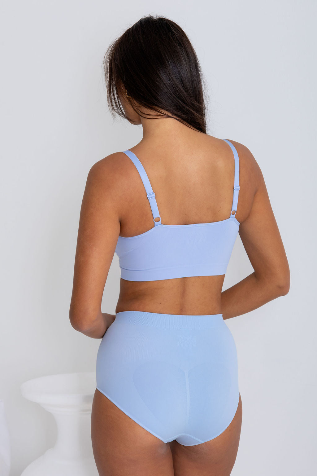 Woman wearing a light blue bikini set against a white background